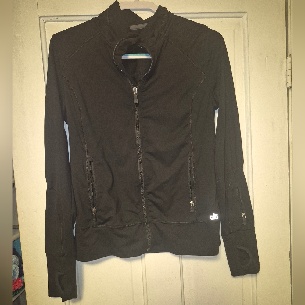 black Alo Yoga athletic zip-up jacket featuring fitted seaming and thumbholes